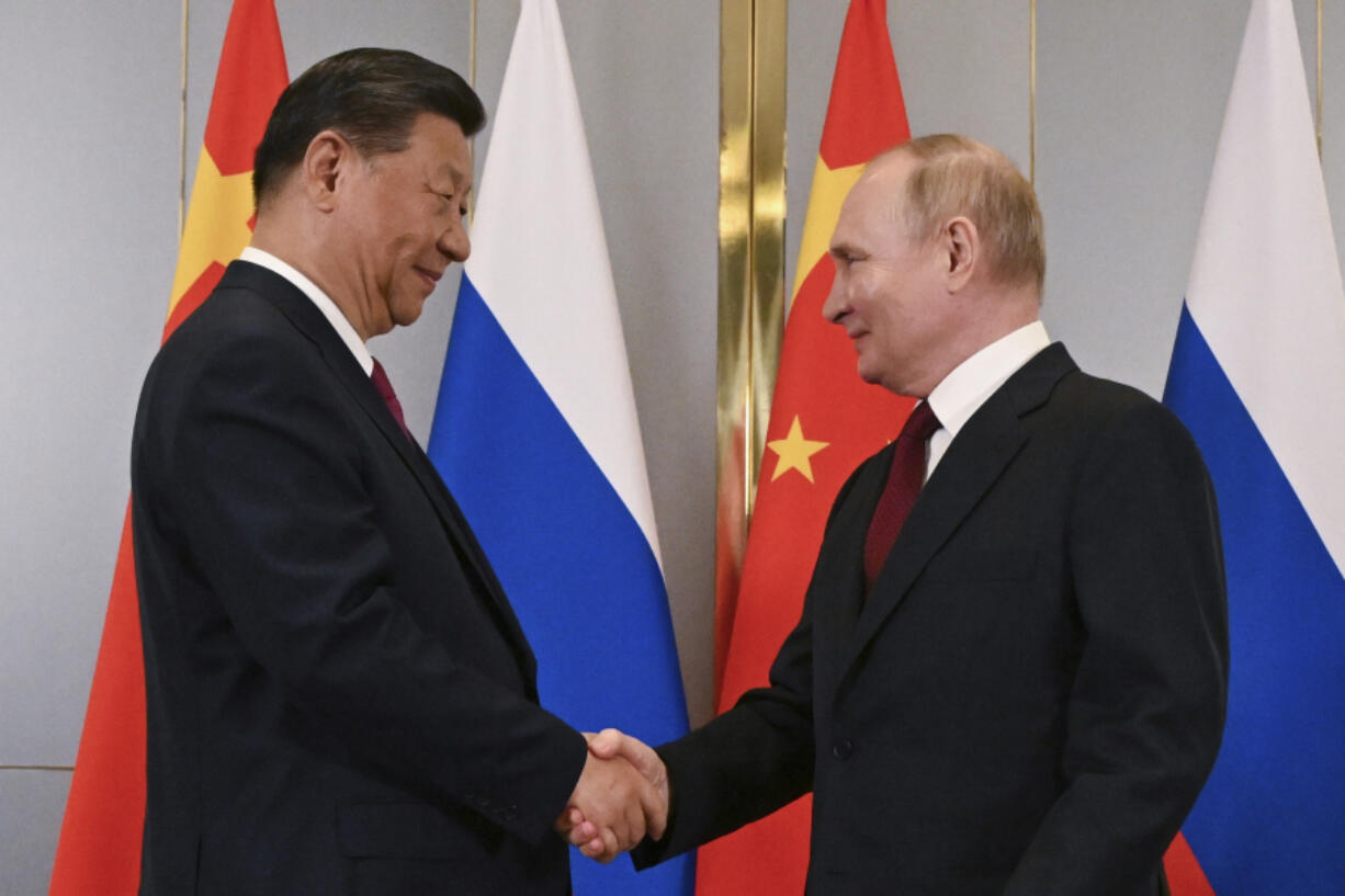 FILE -Russian President Vladimir Putin, right, and Chinese President Xi Jinping shake hands during their meeting on the sidelines of the Shanghai Cooperation Organisation (SCO) summit in Astana, Kazakhstan, July 3, 2024. China has accused NATO of seeking security at the expense of others and told the alliance not to bring the same &ldquo;chaos&rdquo; to Asia. The statement from a Foreign Ministry spokesperson on Thursday came a day after NATO labeled China a &ldquo;decisive enabler&rdquo; of Russia&rsquo;s war against Ukraine.