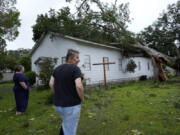 Ann McCauley, right, examines the damage at Bethel Church after Hurricane Beryl moved through the area July 8 in Van Vleck, Texas.