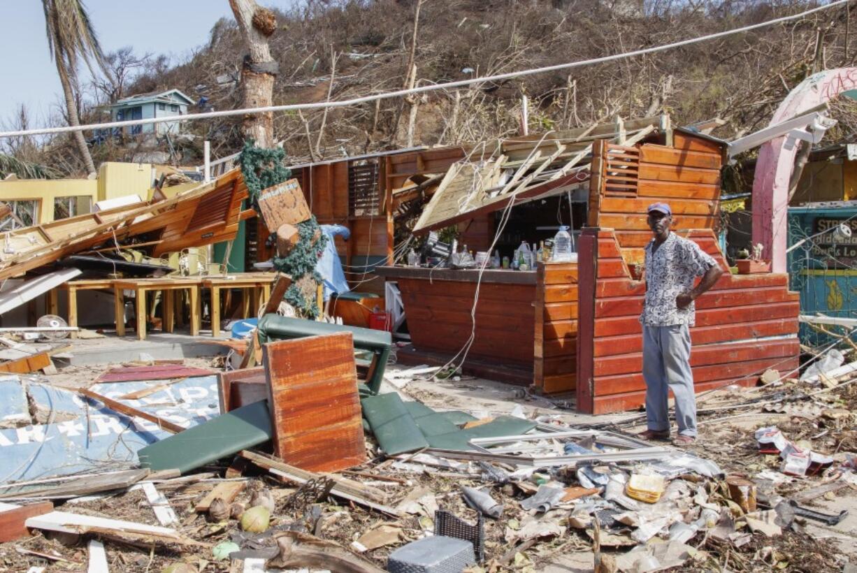 FILE - A man stands next to a business destroyed by Hurricane Beryl in Clifton, Union Island, St. Vincent and the Grenadines, July 4, 2024.