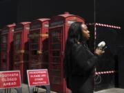 A woman cools herself with a fan June 26 during a hot day in London.