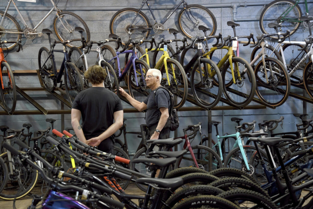 FILE - Customer Dan Inks, right, shops at University Bicycles in Boulder, Colo., on April 30, 2024. On Tuesday, July 30, 2024, the Conference Board reports on U.S. consumer confidence for July.