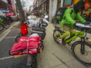 FILE - A food delivery worker rides down a sidewalk after a pickup from a restaurant in New York on Jan. 29, 2024. DoorDash is stepping up efforts to stop delivery drivers who are breaking traffic laws.