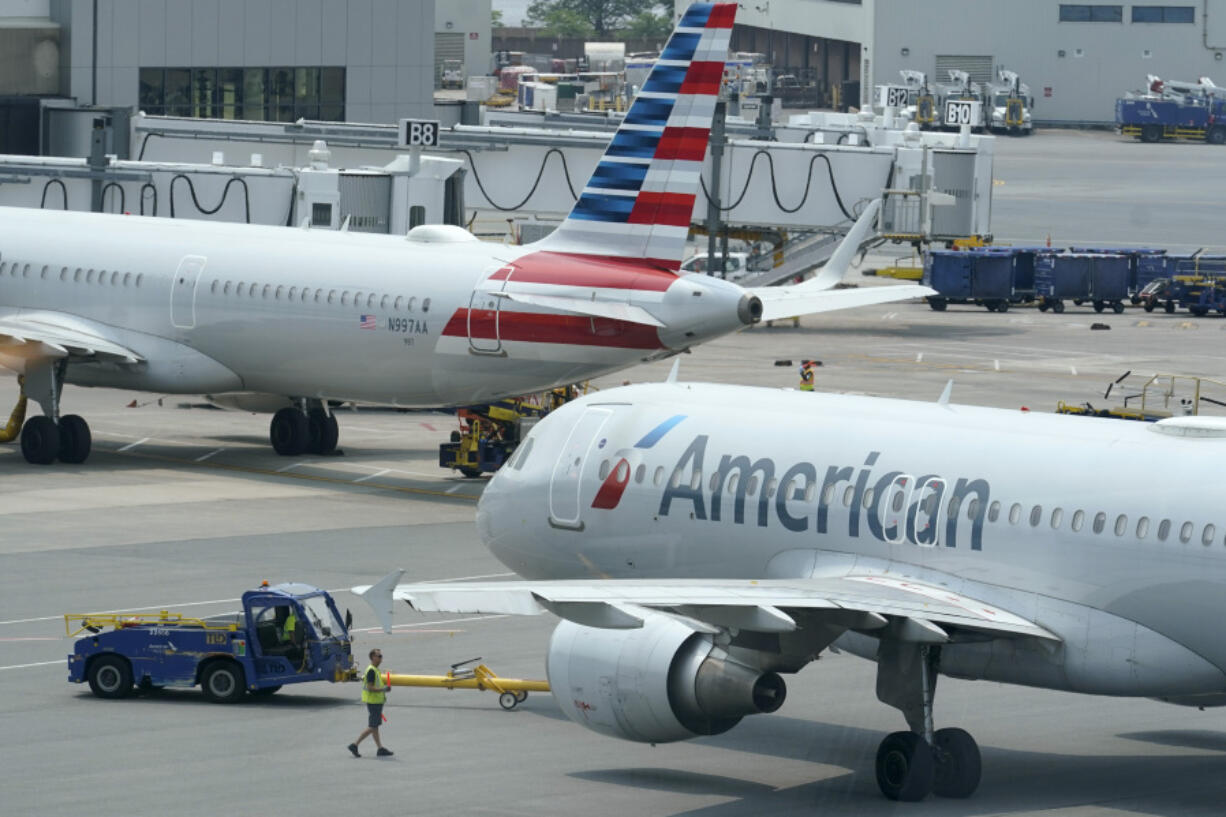 FILE - American Airlines passenger jets prepare for departure, July 21, 2021, near a terminal at Boston Logan International Airport in Boston.