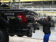 FILE - Assembly line worker Lashunta Harris applies the Ford logo on a 2024 Ford F-150 truck being assembled at the Dearborn Truck Plant, April 11, 2024, in Dearborn, Mich. On Friday, June 5, 2024, the U.S. government issues its June jobs report.