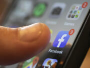 FILE - An iPhone displays the Facebook app, Aug. 11, 2019, in New Orleans. Russia, China and Iran are continuing to target voters in the U.S. with disinformation and propaganda related to the upcoming presidential election, top intelligence officials told reporters on Monday, July 29, 2024. Groups linked to the Kremlin are increasingly using private public relations firms or unwitting social media users to spread their false claims as a way to hide their tracks.