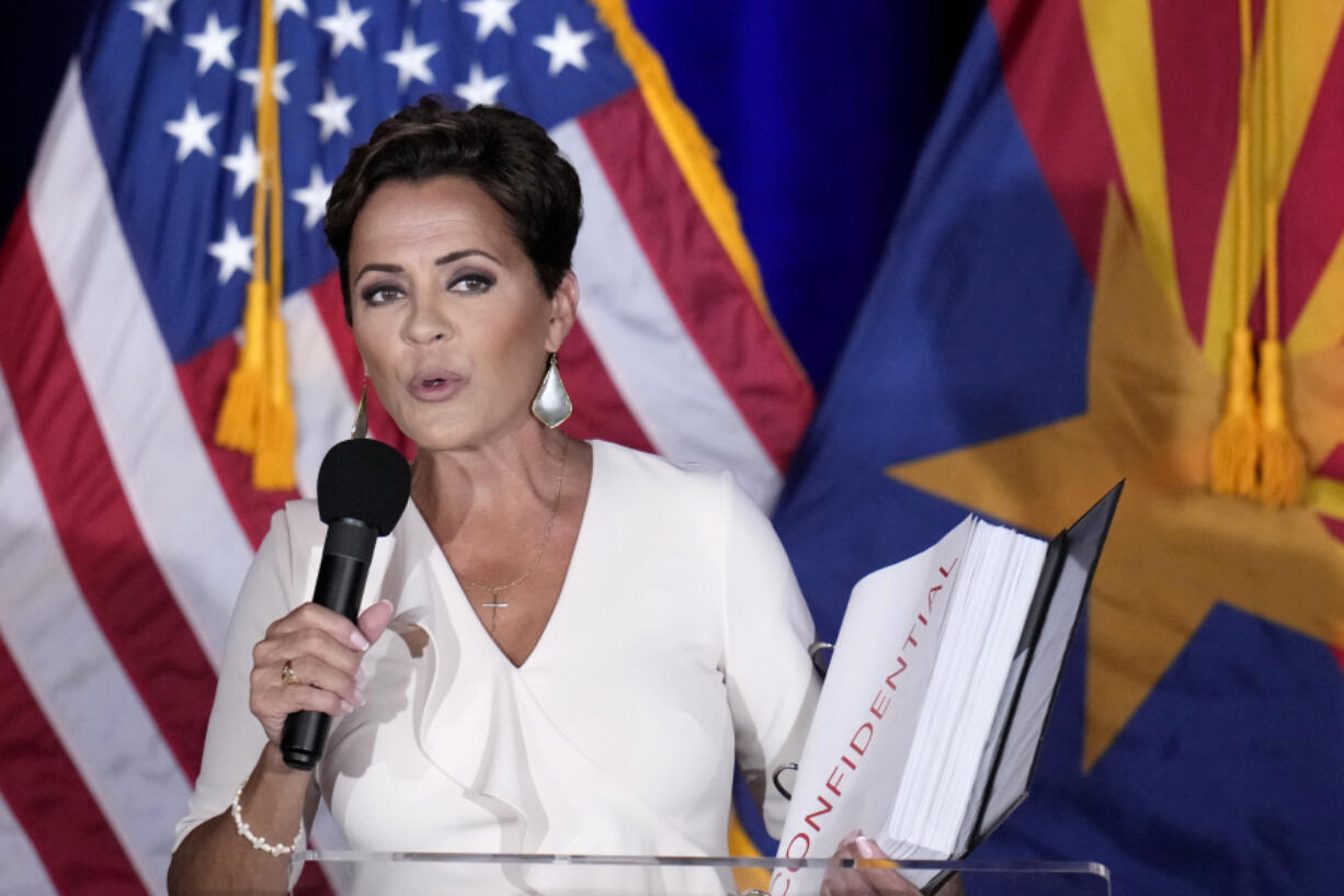 Republican Arizona Senate candidate Kari Lake holds up a binder of Democratic Rep. Ruben Gallego&rsquo;s voting record, Lake&rsquo;s opponent in the upcoming general election, while speaking after being declared the primary winner Tuesday, July 30, 2024, in Phoenix. (AP Photo/Ross D.