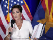 Republican Arizona Senate candidate Kari Lake holds up a binder of Democratic Rep. Ruben Gallego&rsquo;s voting record, Lake&rsquo;s opponent in the upcoming general election, while speaking after being declared the primary winner Tuesday, July 30, 2024, in Phoenix. (AP Photo/Ross D.