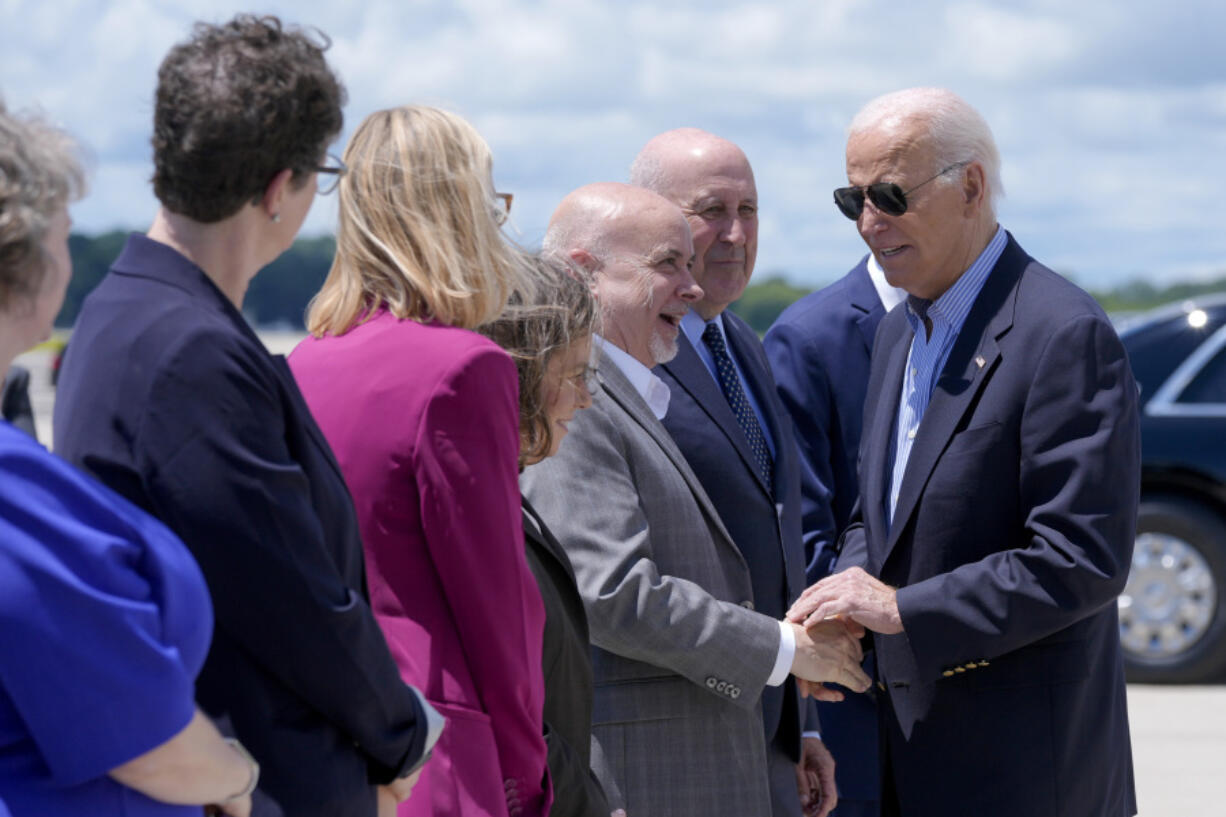 President Joe Biden, right, shakes hands with Rep. Mark Pocan, D-Wis., as former Wisconsin Gov. Jim Doyle, second from right, looks on, upon arriving at Dane County Regional Airport to attend a campaign rally in Madison, Wis., Friday, July 5, 2024.