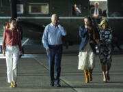 President Joe Biden talks on the phone as he walks to board Air Force One at McGuire Air Force Base, Saturday, June 29, 2024, in Burlington County, N.J. From left, Natalie Biden, Biden, Finnegan Biden, and first lady Jill Biden.