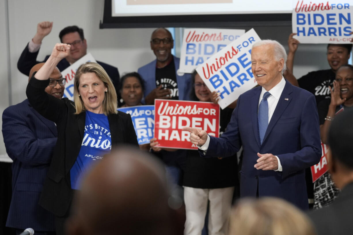 President Joe Biden arrives for a visit to AFL-CIO headquarters, Wednesday, July 10, 2024, in Washington, as AFL-CIO president Liz Shuler, left, cheers.