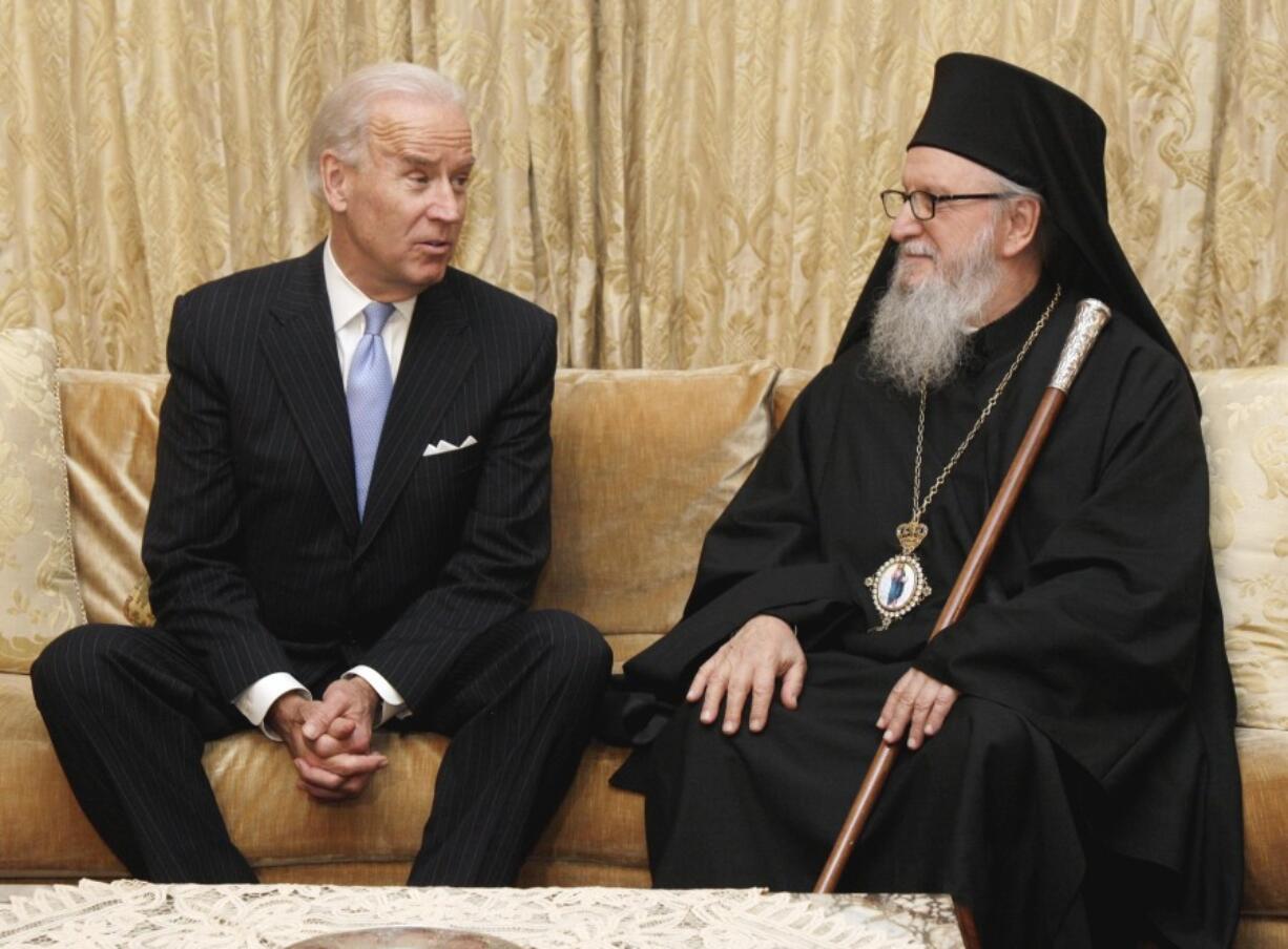 FILE - Vice President Joe Biden poses for photos with Archbishop Demetrios, the Primate of the Greek Orthodox Church in America, at the beginning of their meeting, in New York, Nov. 16, 2011. Historians and political advisers say history will be kinder to President Joe Biden than voters have been. Biden dropped out of the presidential race Sunday, July 21, 2024, clearing the way for a new Democratic nominee.