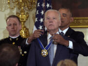 President Barack Obama presents Vice President Joe Biden with the Presidential Medal of Freedom during a ceremony in the State Dining Room of the White House in Washington, Jan. 12, 2017.
