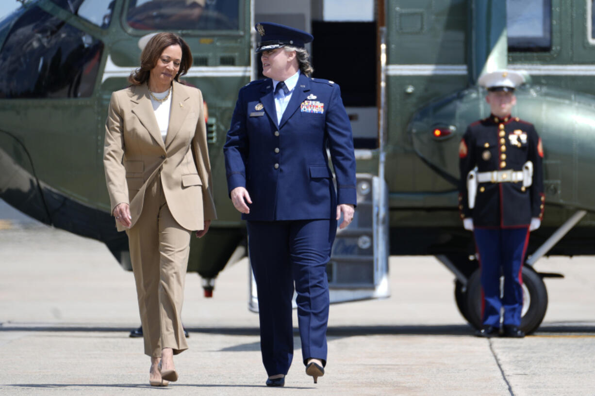 Vice President Kamala Harris, left, arrives to board Air Force Two at Andrews Air Force Base in Md., Saturday, July 27, 2024. Harris is traveling to Pittsfield, Mass., to participate in a political event.