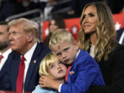 Republican presidential candidate former President Donald Trump sits with Lara Trump and her children Luke and Carolina during the 2024 Republican National Convention at the Fiserv Forum, Thursday, July 18, 2024, in Milwaukee.