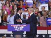 Republican presidential candidate former President Donald Trump and Republican vice presidential candidate Sen. JD Vance, R-Ohio,  greet each other at a campaign rally, Saturday, July 27, 2024, in St. Cloud, Minn.