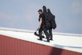 Police snipers walk on a roof to set up before Republican presidential candidate former President Donald Trump speaks at a campaign event in Butler, Pa., on Saturday, July 13, 2023. (AP Photo/Gene J.