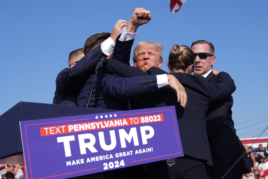 Republican presidential candidate former President Donald Trump gestures as he is surrounded by U.S. Secret Service agents at a campaign rally, Saturday, July 13, 2024, in Butler, Pa.