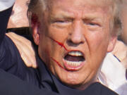 Republican presidential candidate former President Donald Trump reacts following an assassination attempt at a campaign event in Butler, Pa., on Saturday, July 13, 2024. (AP Photo/Gene J.
