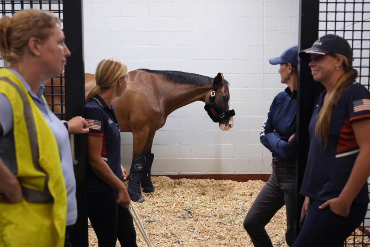 Claire Gallagher of the Dutta Corporation, left, and U.S. Olympic Eventing Team staff wait for approval to move a team horse to a cargo stall July 17 at The Ark at John F.