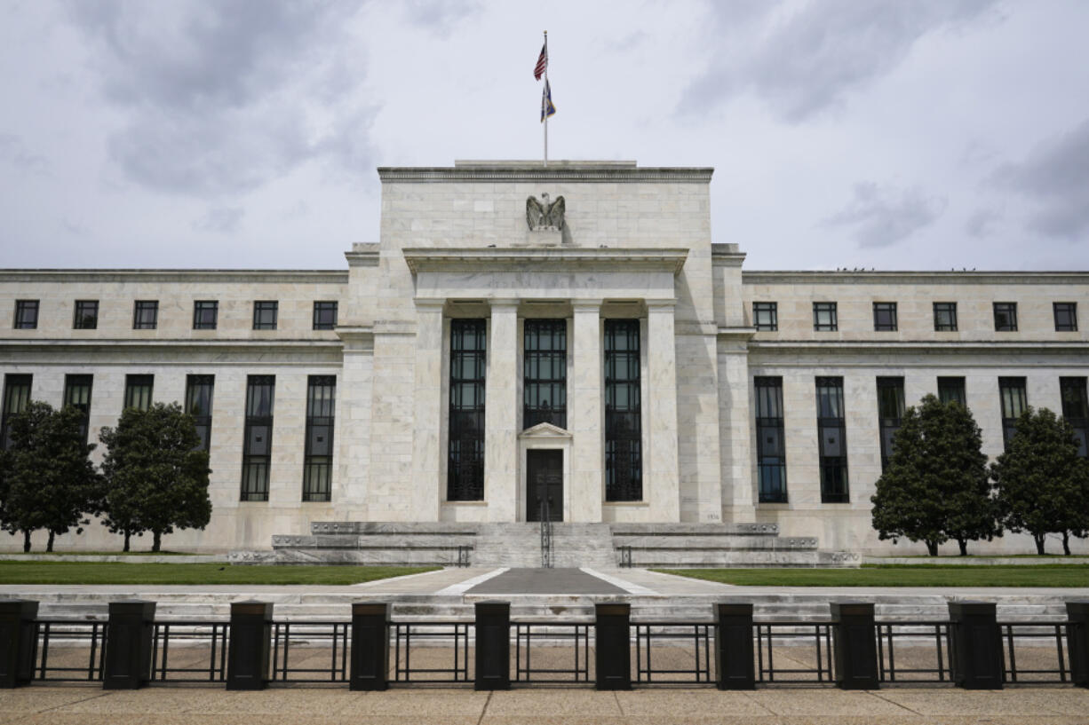 FILE - An American flag flies over the Federal Reserve building on May 4, 2021, in Washington. With the end of their two-year fight against inflation in sight, Federal Reserve officials on Wednesday, July 31, 2024, are likely to set the stage for the first cut to their key interest rate in four years.