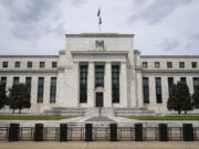 FILE - An American flag flies over the Federal Reserve building on May 4, 2021, in Washington. With the end of their two-year fight against inflation in sight, Federal Reserve officials on Wednesday, July 31, 2024, are likely to set the stage for the first cut to their key interest rate in four years.