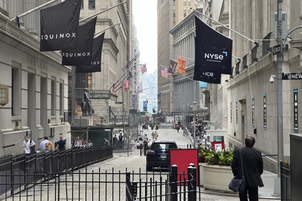 FILE - A man walking on Wall Street approaches the New York Stock Exchange, right, on June 26, 2024, in New York. Shares advanced in Europe on July 1, 2024, with the benchmark in Paris up 2.8% briefly after the far-right National Rally gained a strong lead in first-round legislative elections.