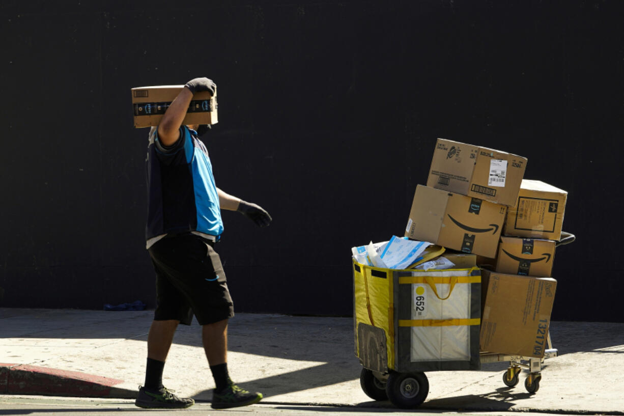 FILE - An Amazon worker delivers packages in Los Angeles on Oct. 1, 2020. July sales events have become a seasonal revenue driver for the retail industry since Amazon launched its first Prime Day back in 2015.