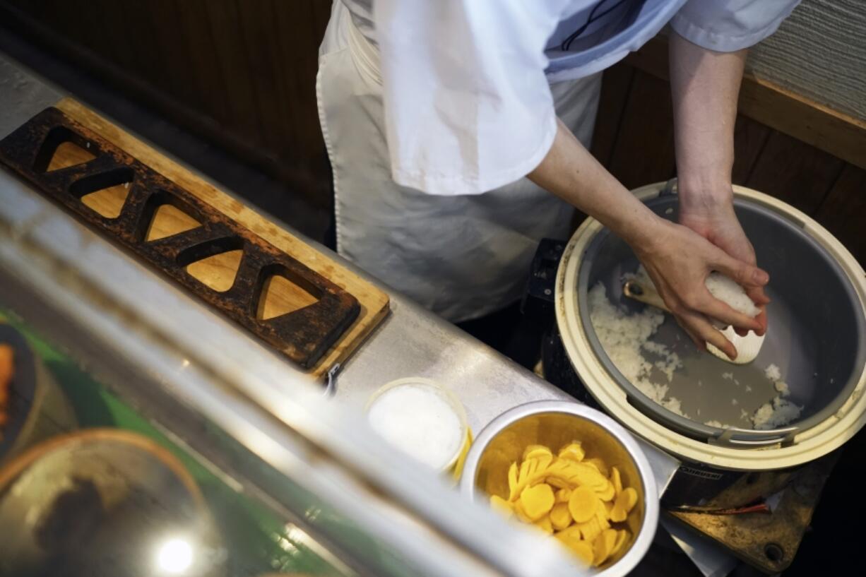 Yosuke Miura prepares to make a rice ball at Onigiri Asakusa Yadoroku, Tokyo&rsquo;s oldest onigiri restaurant, Monday, June 3, 2024, in Tokyo.