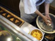 Yosuke Miura prepares to make a rice ball at Onigiri Asakusa Yadoroku, Tokyo&rsquo;s oldest onigiri restaurant, Monday, June 3, 2024, in Tokyo.