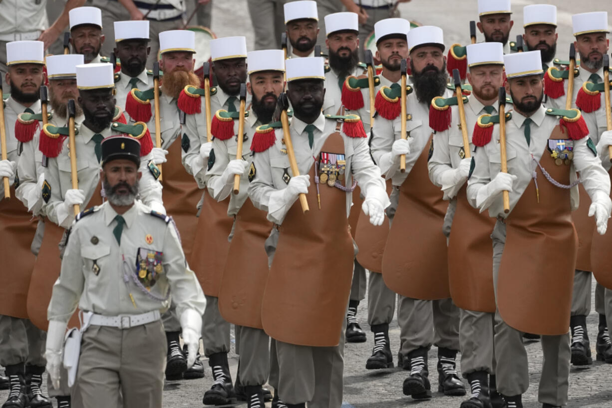 Troops of the Foreign Legion parade during the Bastille Day parade, Sunday, July 14, 2024 in Paris. The Olympic flame is lighting up the city&rsquo;s grandiose Bastille Day military parade. It&rsquo;s 12 days before the French capital hosts exceptionally ambitious and high-security Summer Games.