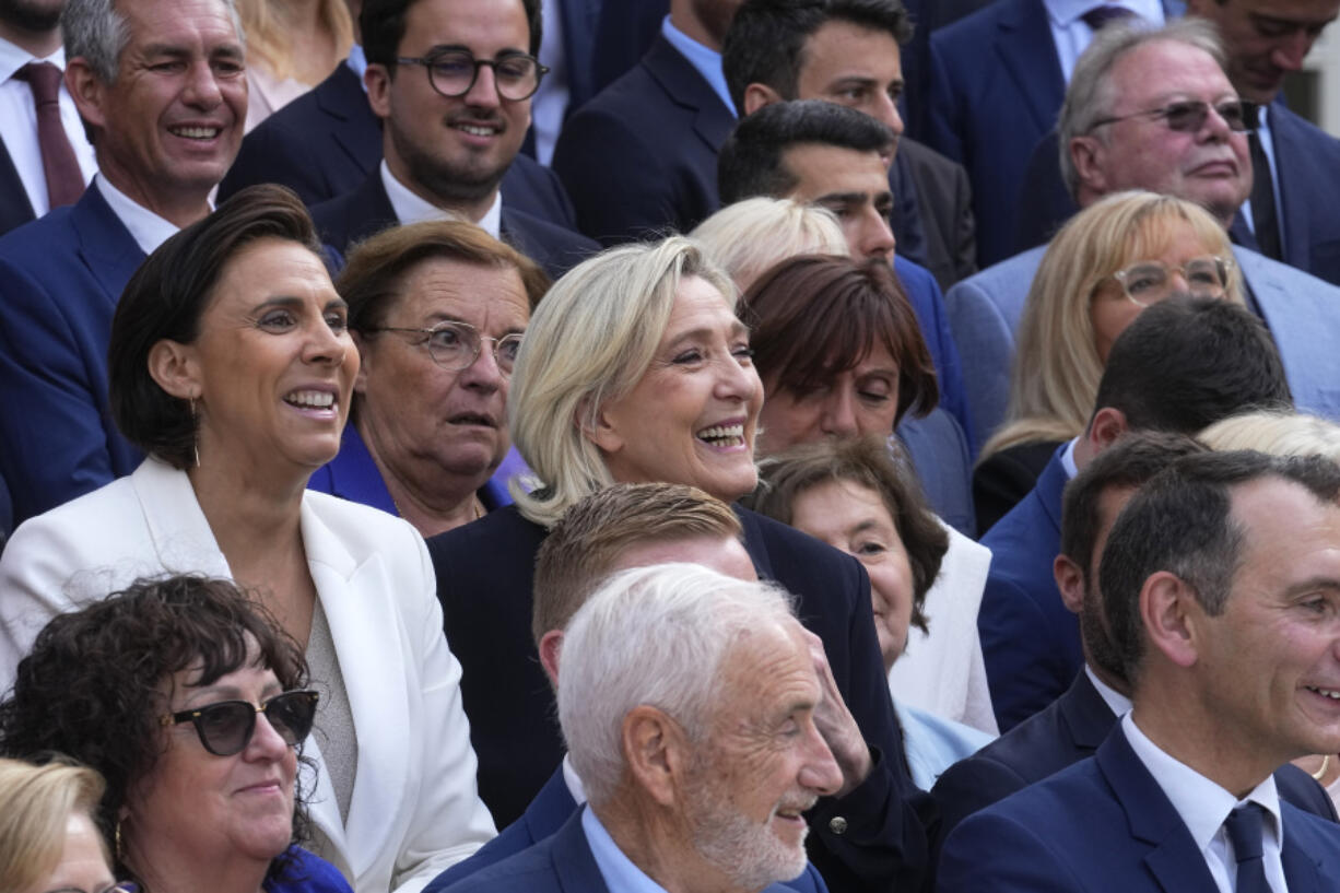 French far-right leader Marine Le Pen, center, poses with newly elected parliament members of the National Rally party at the National Assembly Wednesday, July 10, 2024 in Paris. French voters have given a broad leftist coalition the most parliamentary seats in a pivotal legislative election that has kept the far right from power but has put France in the unprecedented position of having no dominant political bloc in parliament.