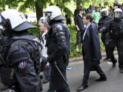 Participants of the AfD party conference are escorted by police past demonstrators in Essen, Germany, Saturday June 29, 2024. The far-right Alternative for Germany party is holding a convention in the western city of Essen and large-scale protests against the party are taking place.