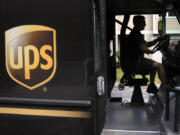 FILE - A United Parcel Service driver steers through a neighborhood while delivering packages, June 30, 2023, in Haverhill, Mass. As areas across the U.S. continue to experience extreme heat, employers have taken steps to protect workers from high temperatures. UPS has added more cooling equipment to its vehicles and facilities.