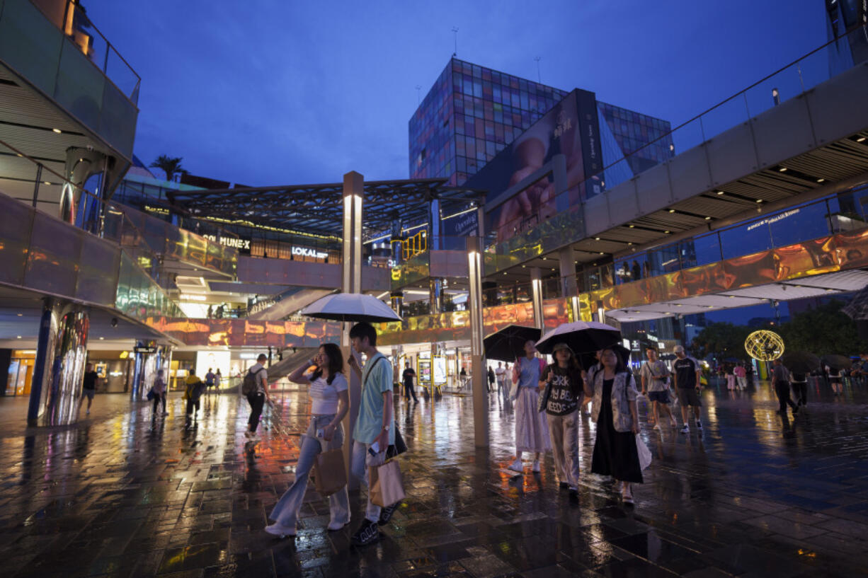 FILE - People shop at Taikoo Li Sanlitun shopping center in Beijing, China, on July 2, 2024. On Tuesday, July 16, 2024, the International Monetary Fund issues an update to its World Economic Outlook, a forecast for the global economy and major nations.