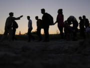 FILE - Migrants who crossed the Rio Grande and entered the U.S. from Mexico are lined up for processing by U.S. Customs and Border Protection, Sept. 23, 2023, in Eagle Pass, Texas.  U.S. authorities say border arrests during July have plummeted to a new low for Joe Biden&rsquo;s presidency, raising prospects that a temporary ban on asylum may be lifted soon. The Border Patrol is expected to arrest migrants about 57,000 times during the month, down about 30% from June and the lowest tally since September 2020, when COVID-19 slowed movement across many borders.