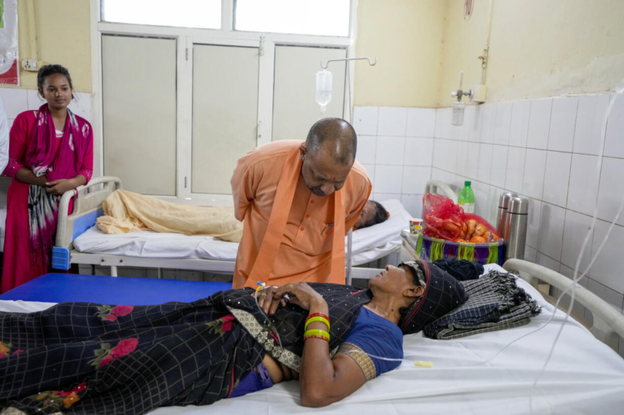 Uttar Pradesh State Chief Minister Yogi Adityanath, talks to a woman who was injured in a stampede as she receives treatment at Hathras district hospital, Uttar Pradesh, India, Wednesday, July 3, 2024. Thousands of people at a religious gathering rushed to leave a makeshift tent, setting off a stampede Tuesday that killed more than hundred people and injured scores.