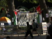 FILE - People walk past the Gaza Solidarity Encampment at the University of Pennsylvania in Philadelphia, Tuesday, April 30, 2024. In the wake of pro-Palestinian protesters on college campuses calling for universities to divest from Israel, Pennsylvania&rsquo;s state Senate on Thursday, June 27, 2024, approved legislation that would block state aid from going to any university that boycotts or divests from Israel.