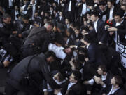 FILE - Israeli police officers disperse Ultra-Orthodox Jewish men blocking a highway during a protest against army recruitment in Bnei Brak, Israel,  June 27, 2024. The Israeli military said it will begin sending draft notices to Jewish ultra-Orthodox men on Sunday, July 21.