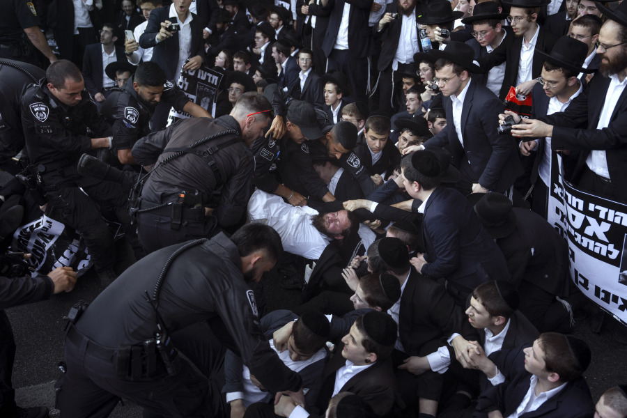 FILE - Israeli police officers disperse Ultra-Orthodox Jewish men blocking a highway during a protest against army recruitment in Bnei Brak, Israel,  June 27, 2024. The Israeli military said it will begin sending draft notices to Jewish ultra-Orthodox men on Sunday, July 21.