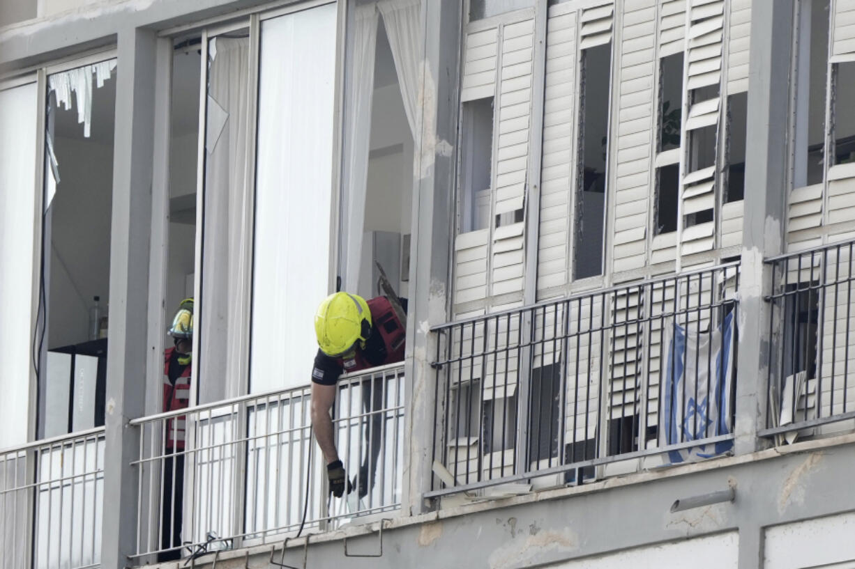 An Israeli firefighter investigates the scene of a deadly explosion in Tel Aviv, Israel, Friday, July 19, 2024.