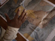 Tariq Hathaleen with a map showing the West Bank village of Umm al-Khair, top, and the Israeli settlement of Carmel Wednesday, July 10, 2024.