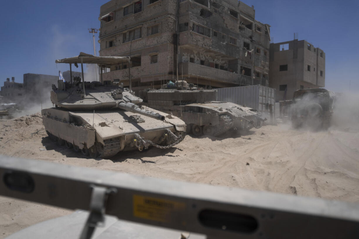 Israeli tanks are seen next to destroyed buildings in the southern Gaza Strip, Wednesday, July 3, 2024. The Israeli military invited reporters for a tour of Rafah, where the military has been operating since May 6.