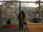 FILE - Women and their children gather in the playground at the end of the day in the settlement outpost of Asa&rsquo;el in the south Hebron hills on Monday, Sept. 4, 2023. The Israeli government has budgeted millions of dollars in security support for small, unofficial Jewish outposts in the Israeli-occupied West Bank, which is enabling the expansion of Jewish settlements while circumventing the official planning process, according to a human rights group.