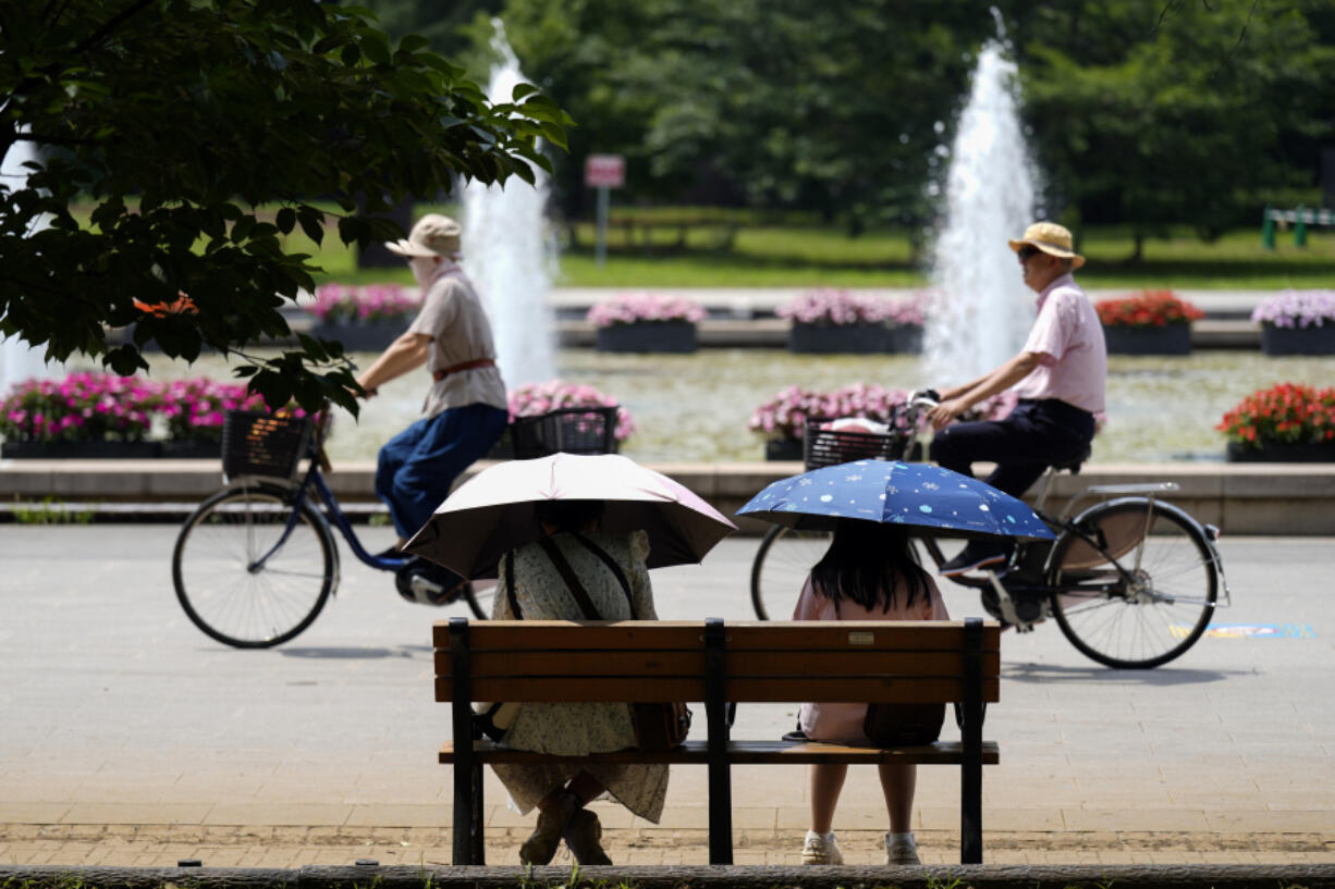 People sit on a bench under an intense sun at a park in Tokyo on July 8. Japan&rsquo;s total population marked its 15th straight year of decline, according to government data released Wednesday.