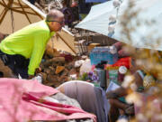 Louis Lacey, director of homeless response teams at Help of Southern Nevada, speaks to a homeless woman to offer water in Las Vegas, on Tuesday, July 9, 2024. Help of Southern Nevada travels the streets with flyers about heat, water and vehicles to transport people to cooling centers.