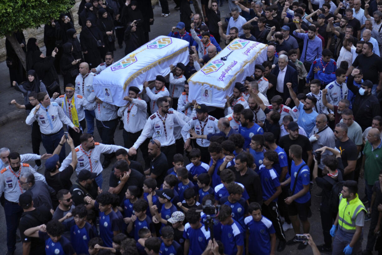 Members of Hezbollah&rsquo;s al-Mahdi scouts, carry the coffins of Amira and Hassan Fadlallah during a funeral procession in a southern suburb of Beirut, Lebanon, Wednesday, July 31, 2024. Hassan Fadlallah and his sister Amira were killed inside a building that was hit by an Israeli airstrike on Tuesday evening.