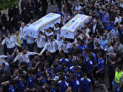 Members of Hezbollah&rsquo;s al-Mahdi scouts, carry the coffins of Amira and Hassan Fadlallah during a funeral procession in a southern suburb of Beirut, Lebanon, Wednesday, July 31, 2024. Hassan Fadlallah and his sister Amira were killed inside a building that was hit by an Israeli airstrike on Tuesday evening.