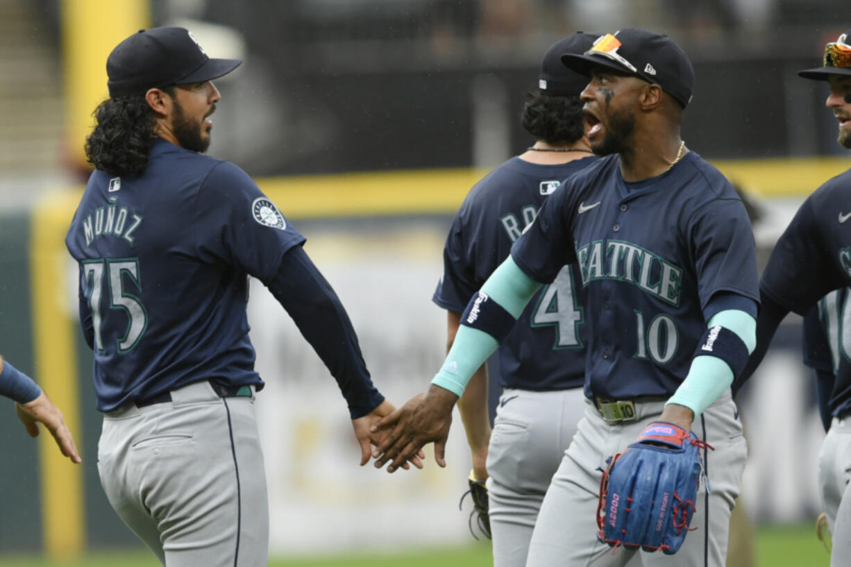 Seattle Mariners closing pitcher Andres Munoz (75) celebrates with teammate Victor Robles (10) after defeating the Chicago White Sox in a baseball game in Chicago, Sunday, July 28, 2024.