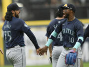 Seattle Mariners closing pitcher Andres Munoz (75) celebrates with teammate Victor Robles (10) after defeating the Chicago White Sox in a baseball game in Chicago, Sunday, July 28, 2024.