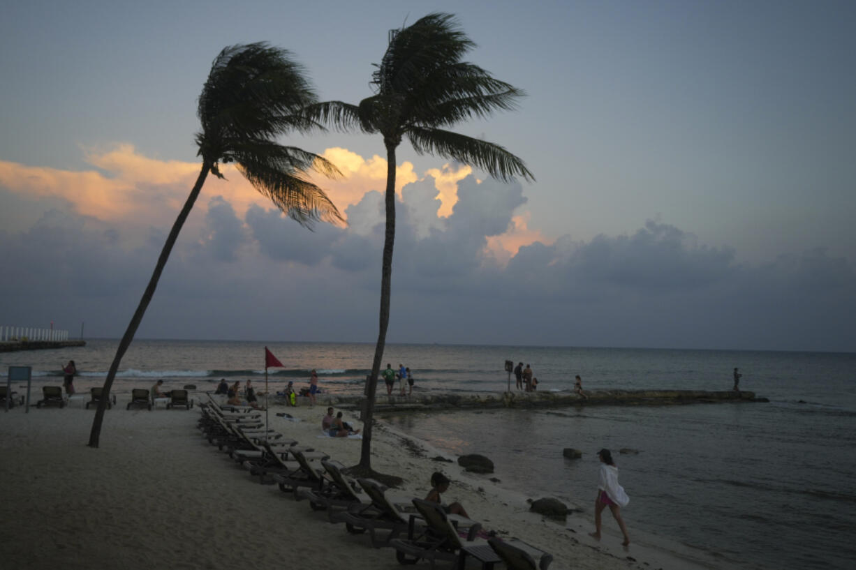 People lounge on the beach as the sun sets ahead of Hurricane Beryl&rsquo;s expected arrival, in Playa del Carmen, Mexico, Wednesday, July 3, 2024.